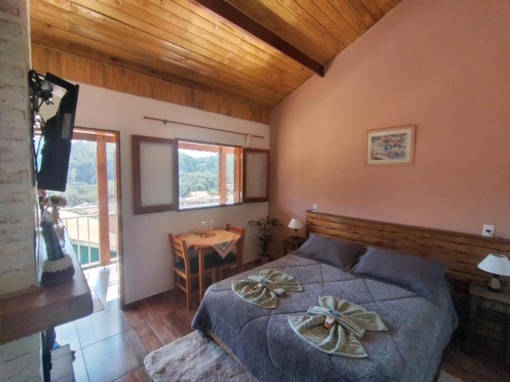 蒙特韦尔迪Recanto lavinia的一间卧室配有一张床、一张桌子和一个窗户。
