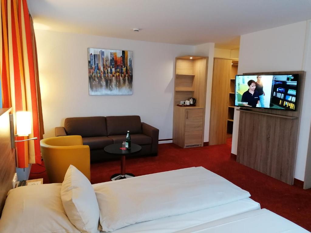 门兴格拉德巴赫门兴格拉德巴赫蒙大拿酒店的酒店客房配有床、沙发和电视。