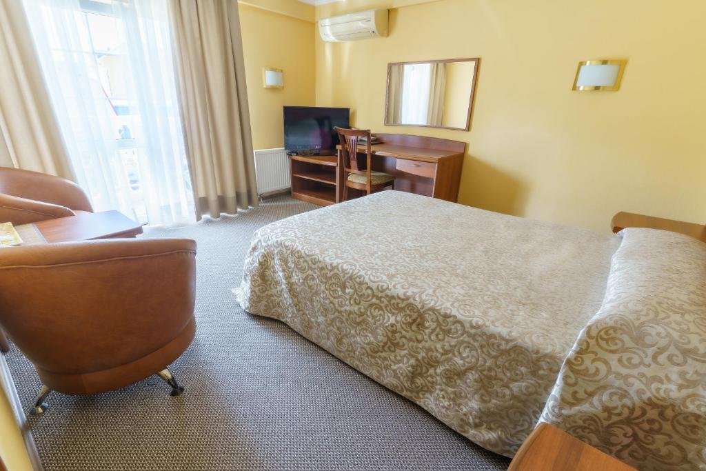 阿德勒玛丽娜酒店的酒店客房配有一张床、一张书桌和一台电视。