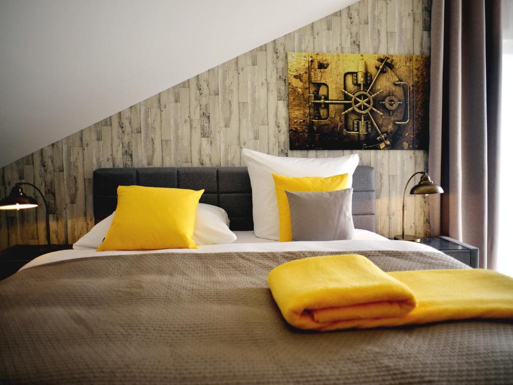 鲁斯特R＆J酒店的一间卧室配有一张带黄色枕头的床