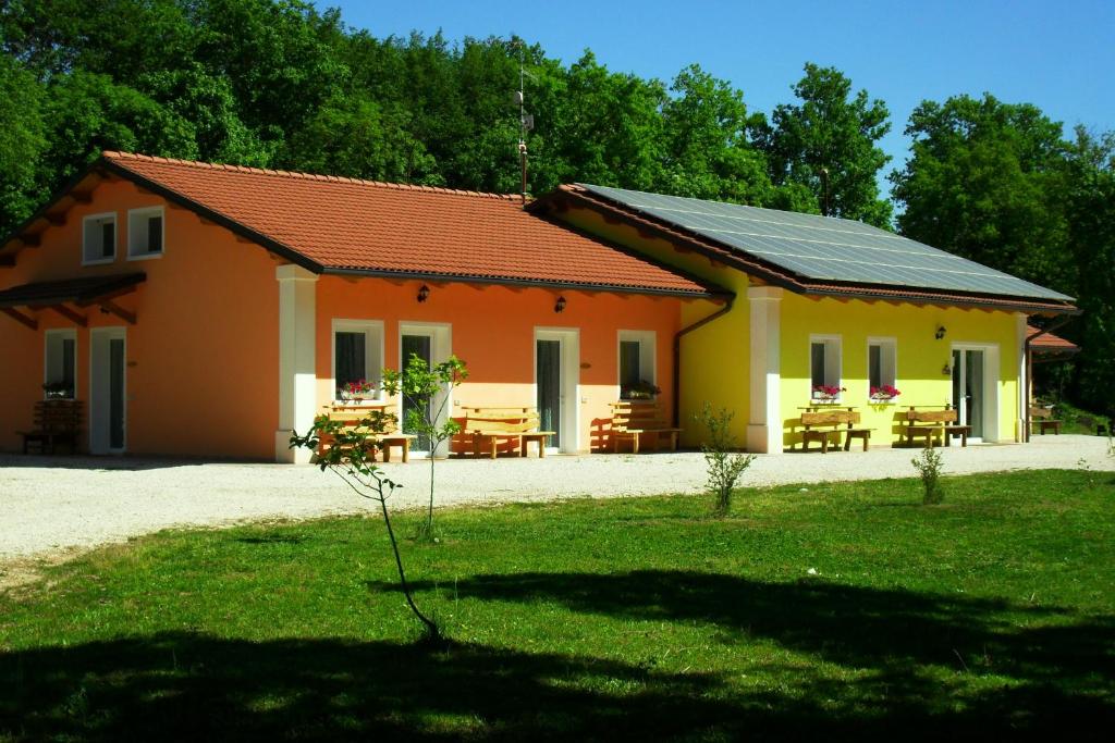 阿尔塔维拉维琴蒂纳Alle Vallesse的黄色和橙色的房子,配有野餐桌