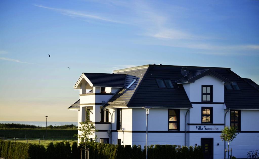 伯尔格伦德-雷特维施Villa Namenlos的黑色屋顶的白色房子