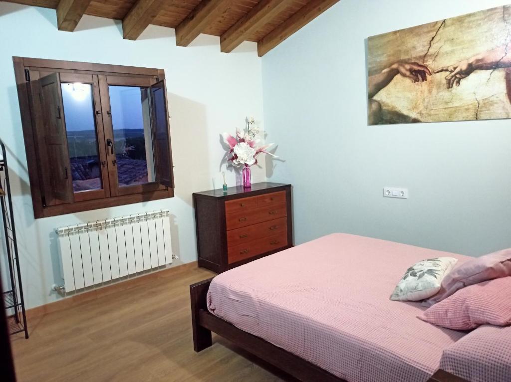圣埃斯特万德戈尔马斯Casa Rural El Mirador de San Miguel的一间卧室配有一张床、一个梳妆台和一扇窗户。