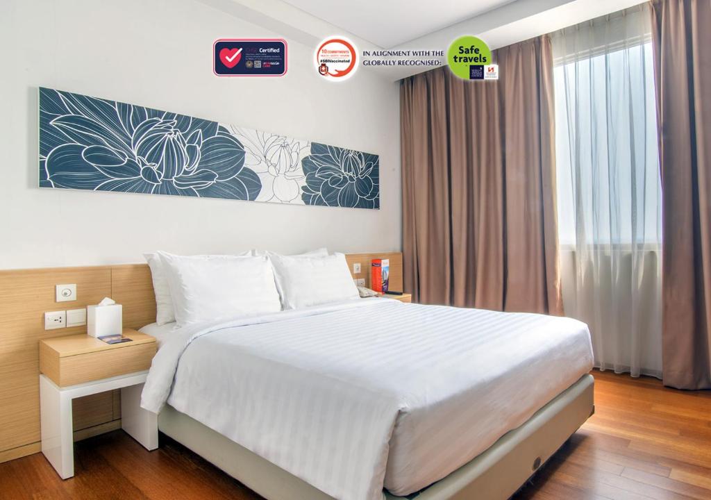 当格浪Swiss-Belinn Airport Jakarta的卧室设有一张白色大床和一扇窗户。