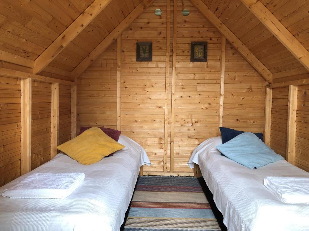 YlämyllyOllilan tupa Joensuun lähellä的小屋设有两张木墙床