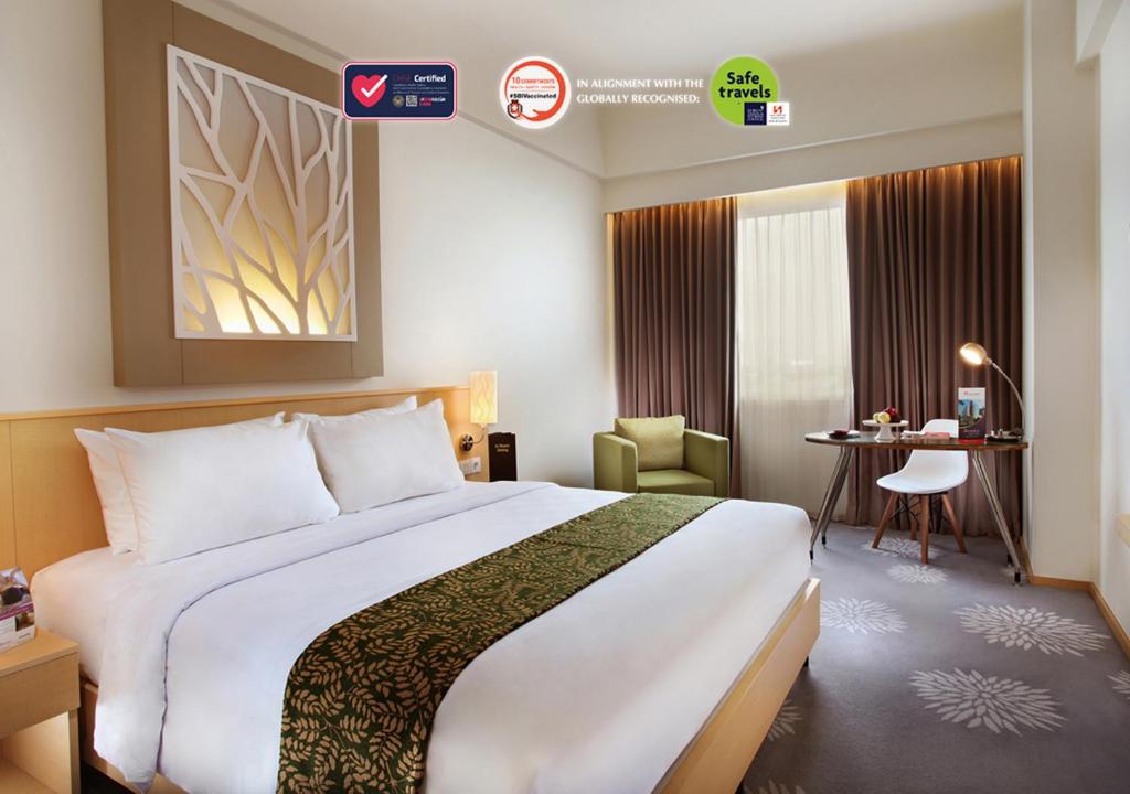 泗水曼亚尔斯维思-贝林酒店的酒店客房设有一张大床和一张书桌。