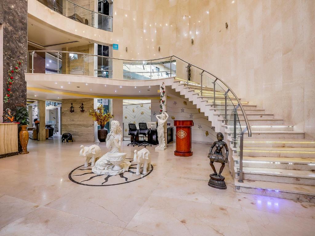 卡兰古特Grandeur De Sanchi- Luxury Beach Resort & Spa的大堂设有楼梯和雕像