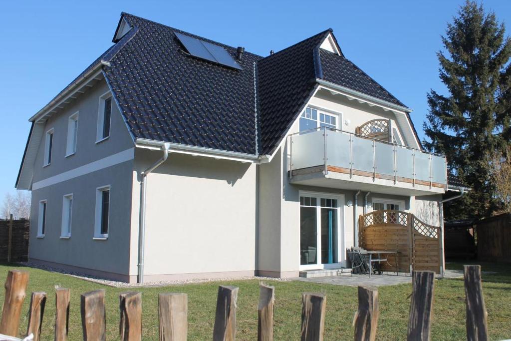 博恩Ferienwohnung van der Holm的白色车库和黑色屋顶的房子