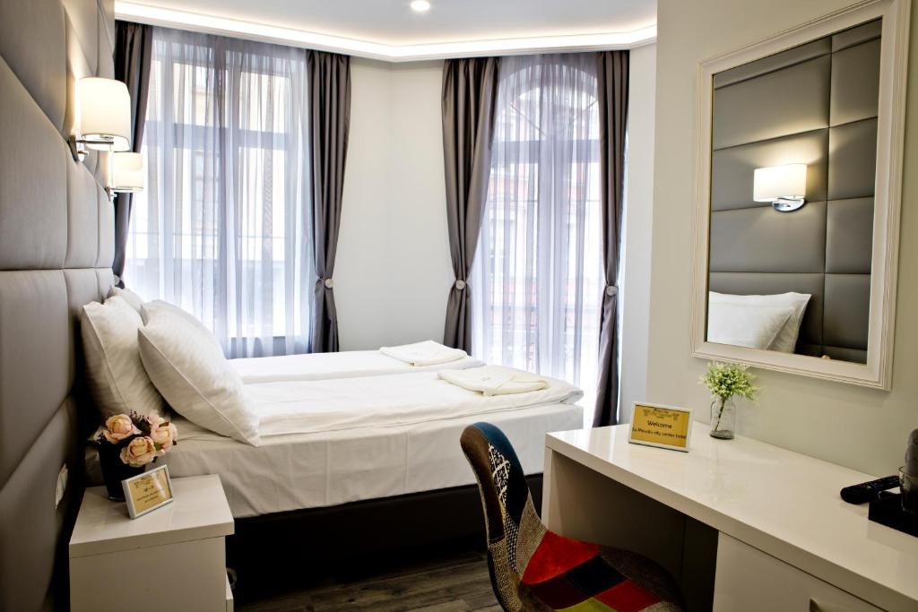 普罗夫迪夫Plovdiv City Center Hotel的酒店客房,配有床和镜子