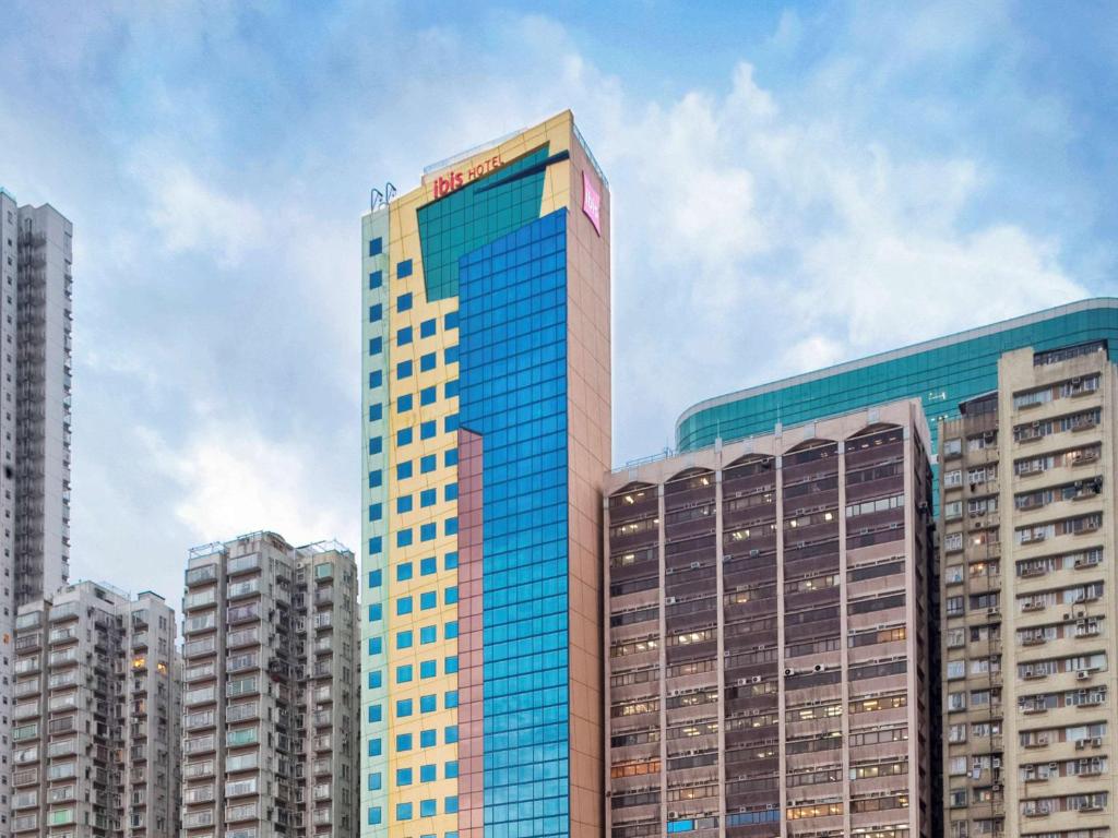 香港宜必思香港北角酒店的一座高大的建筑,有蓝色的窗户,位于城市