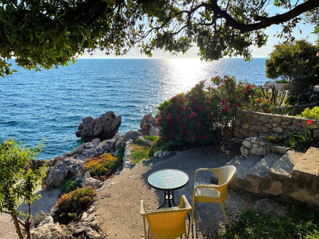 巴尔Luxury Seaside Holm Oak Villa with Private Beach的水边的桌椅