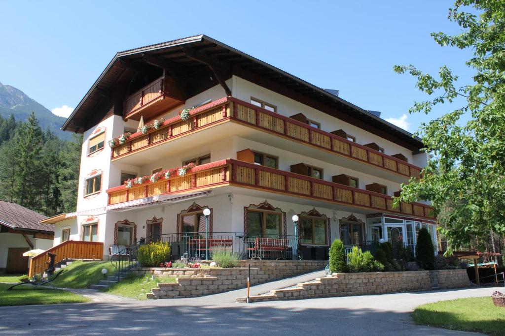 施坦察赫Hotel Garni Waldhof - Wohlfühlen am Lech的一座大型白色建筑,设有阳台