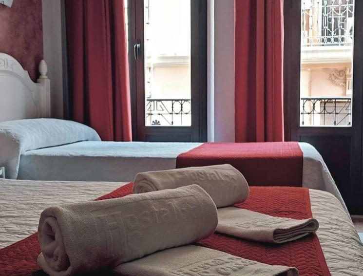 格拉纳达Hostal Sonia Granada的酒店客房,配有两张带毛巾的床