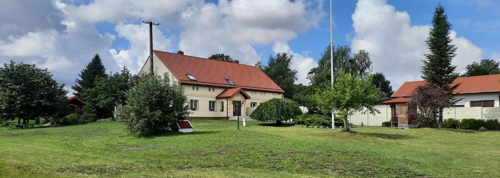 NiemierzeDom wakacyjny-Czereśniowy Sad的绿色田野上红色屋顶的白色房子