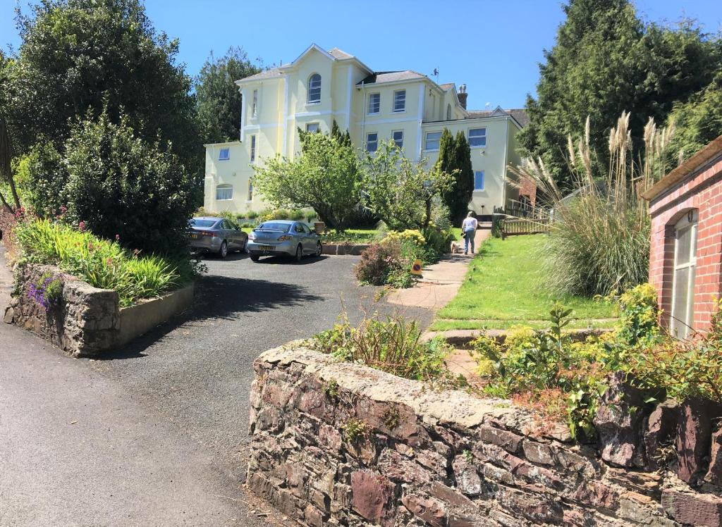 托基Chelston Dene Holiday Apartments的车道上停放汽车的大房子