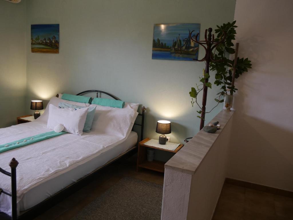 科斯基努Helios Rhodos Apartments的一间卧室配有一张床和盆栽植物