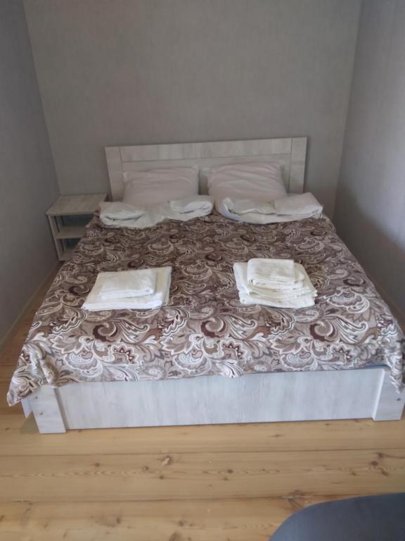 西格纳吉House In The Forest的一张带两张床单和两张毛巾的床