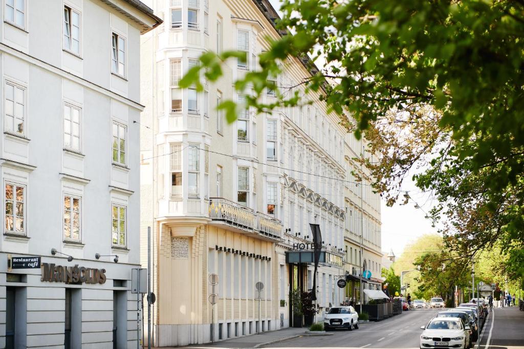 格拉茨Grand Hôtel Wiesler - Centre of Graz的街道上有白色建筑和汽车的街道