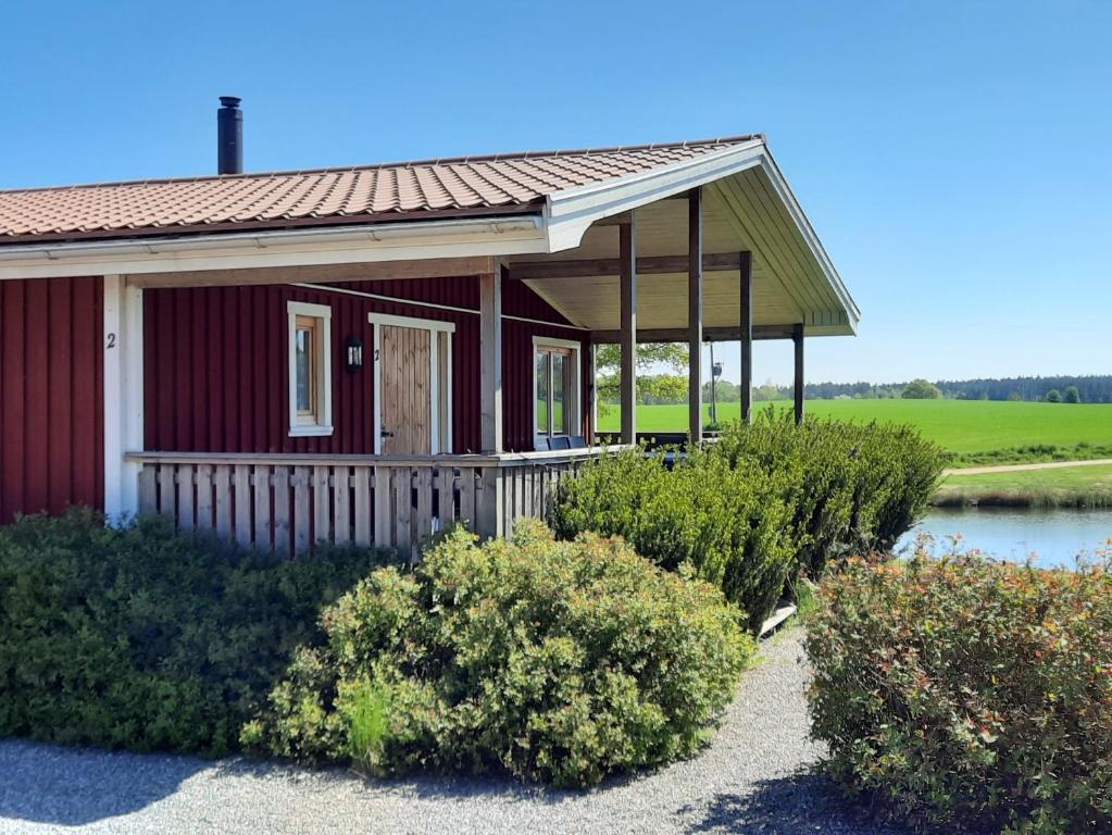 LarvSjötorp säteri & stugby的一座红色的小房子,设有门廊和灌木丛
