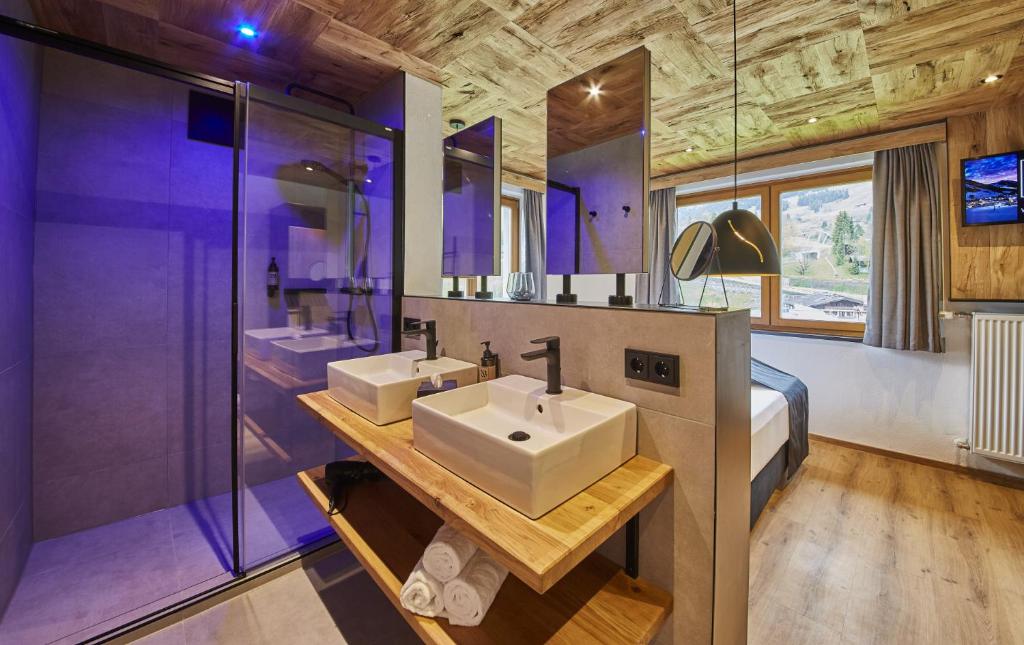 萨尔巴赫Chalet Wallehen的一间带两个盥洗盆和大型淋浴的浴室