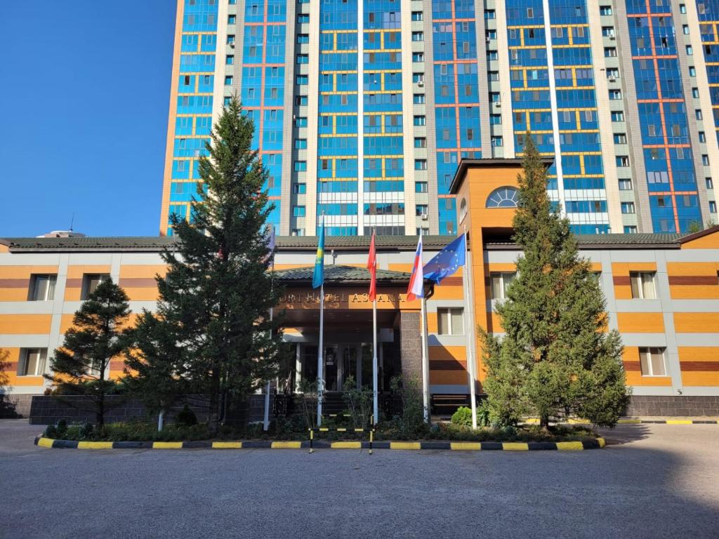 阿斯塔纳Comfort Hotel Astana的前面有树木的大建筑