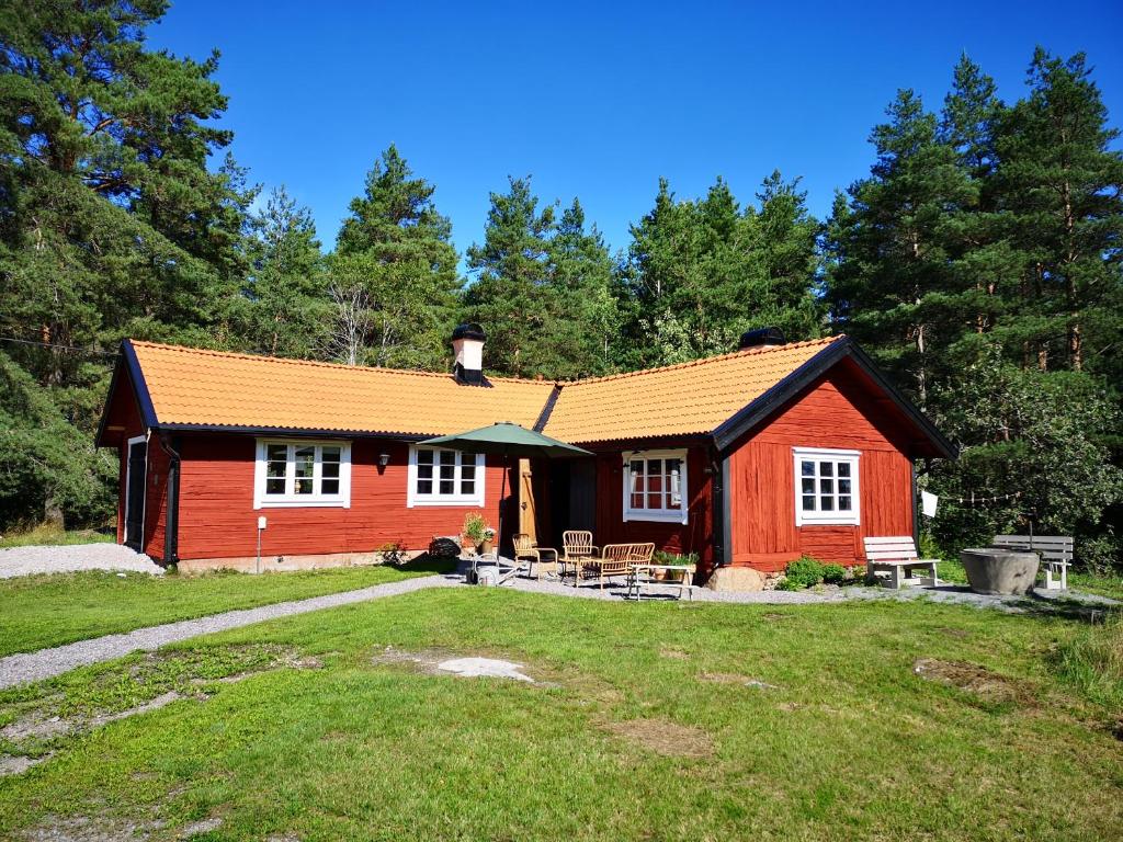 恩雪平Smedjan cottage的一间红色的小房子,前面设有一张野餐桌