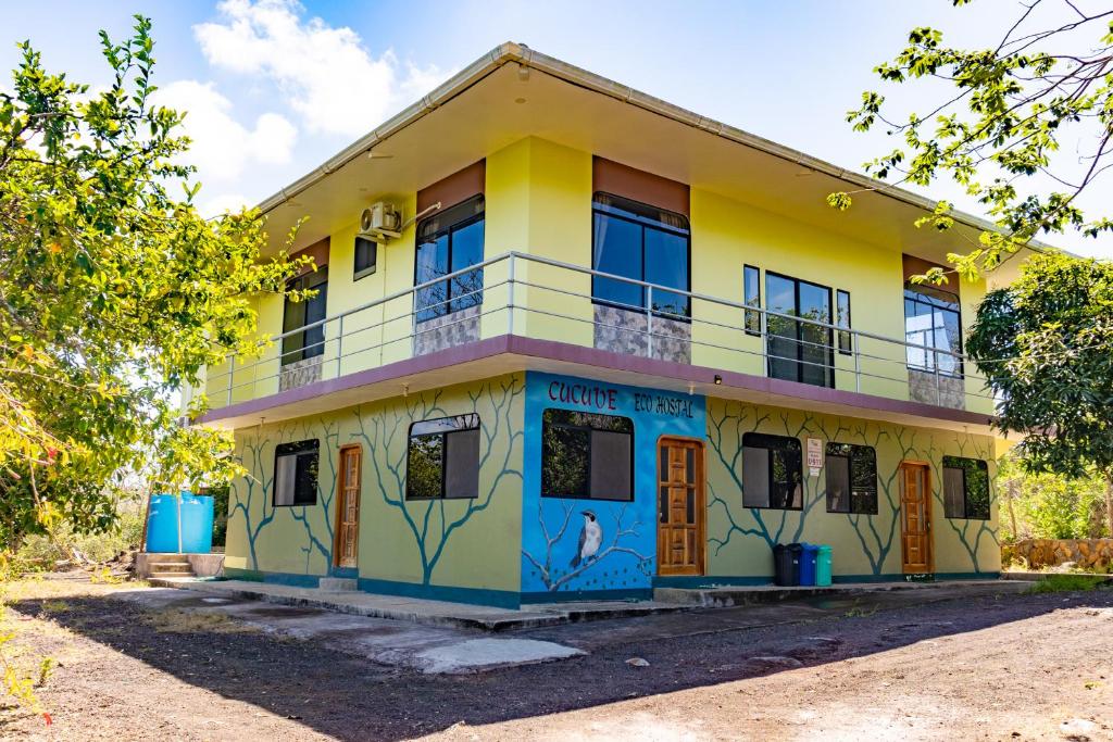 巴克里索莫雷诺港Cucuve Eco Hostal的一座黄色的蓝色建筑,上面涂有涂鸦