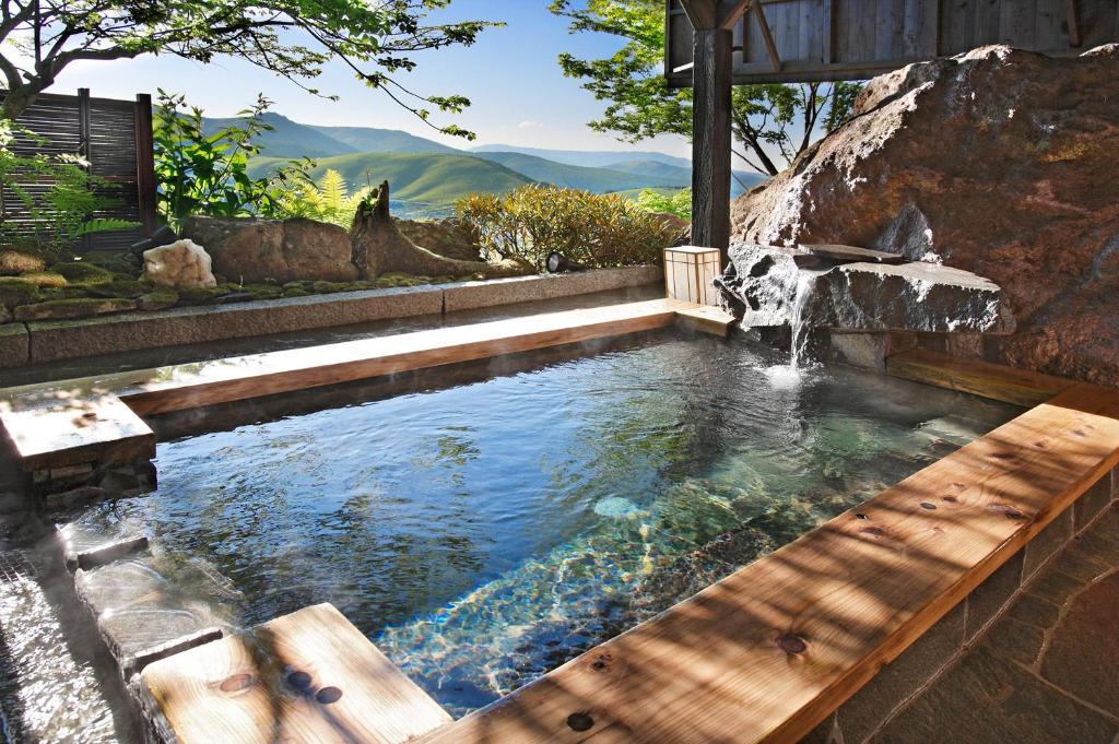 茅野萨维蒙酒店的一个带瀑布的游泳池和一个带瀑布池的游泳池