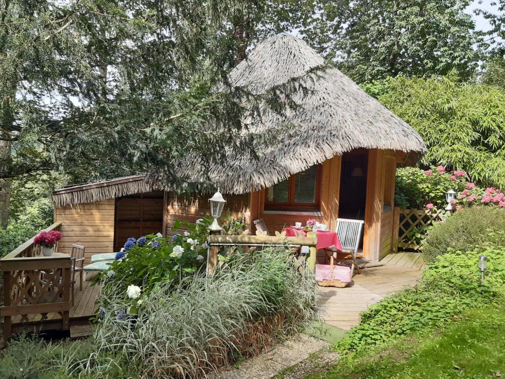 埃特勒塔La Cabane de Cécile-la Hutte的小屋设有茅草屋顶。