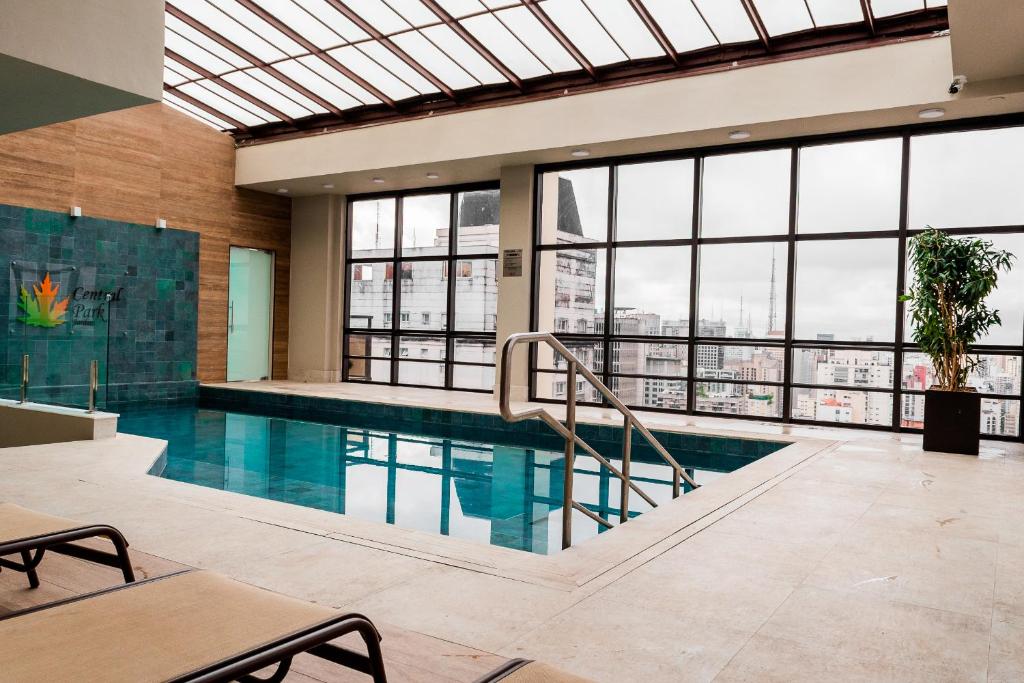圣保罗中央公园花园套房公寓式酒店的一座带窗户的建筑中的游泳池