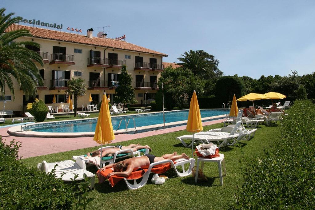 托沙阿卡达酒店的一群人躺在游泳池旁的草坪椅上