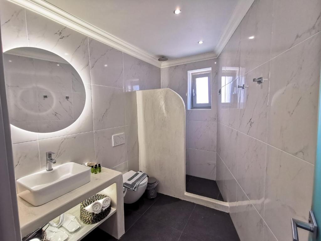莫诺利索斯Noir Santorini的白色的浴室设有水槽和淋浴。