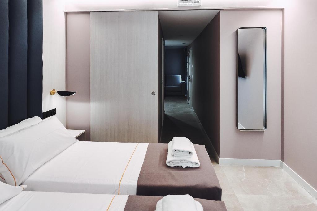 贝尼多姆GBH Hotel-Apartamentos Estrella de Mar的酒店客房,设有两张床和镜子
