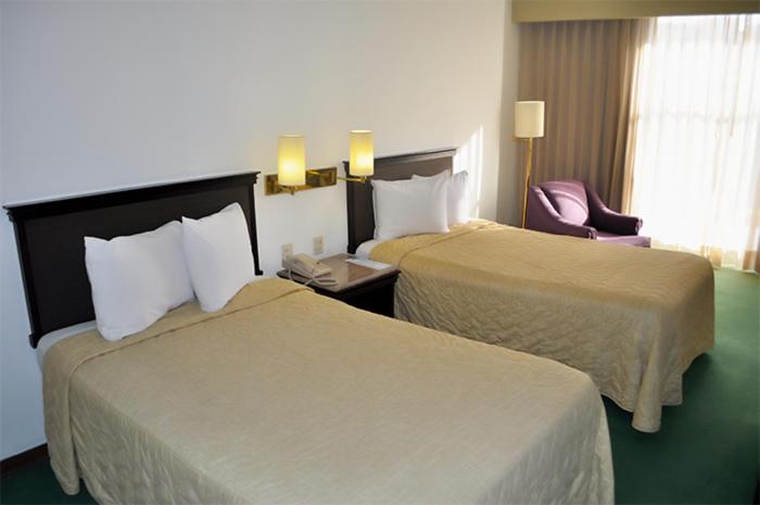 萨卡特卡斯Arroyo Express的酒店客房,配有两张床和椅子