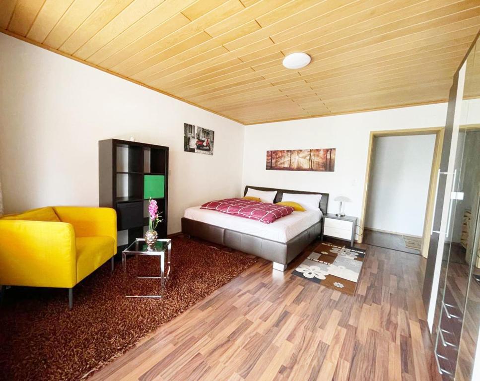 MühlhausenFeWo Royal & Goodness Home的一间卧室配有一张床和一张黄色椅子