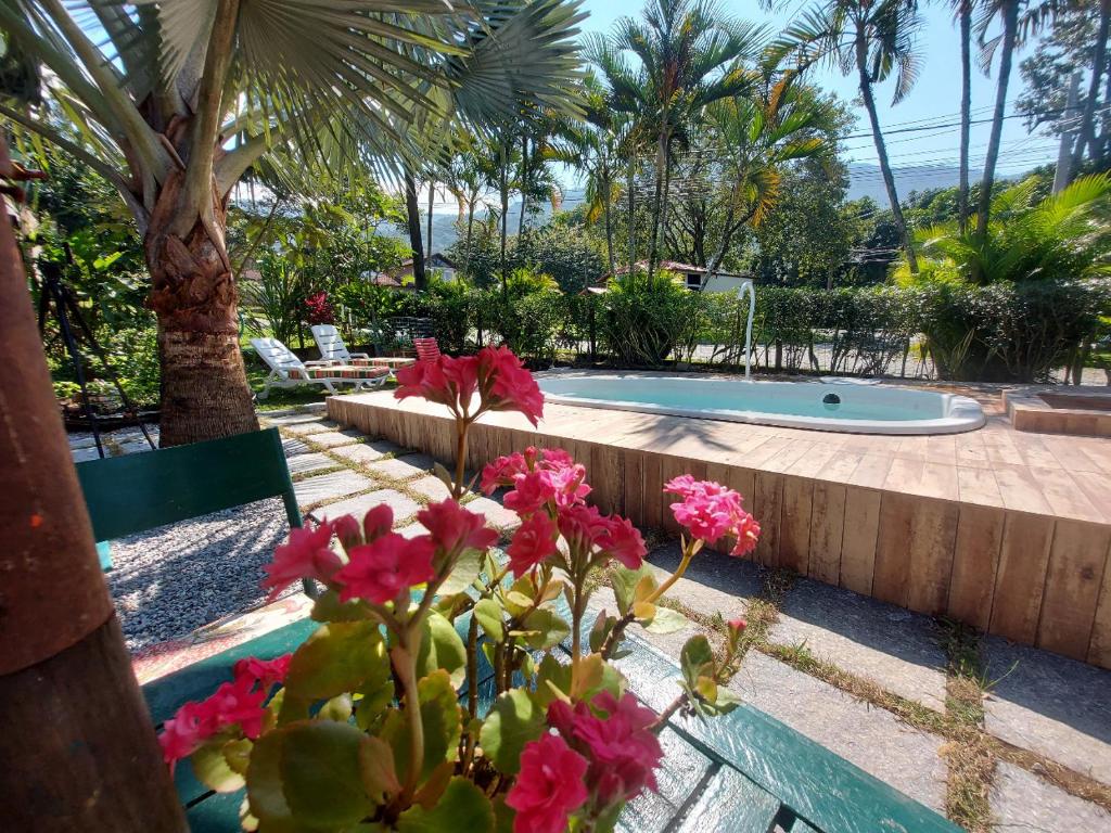 曼加拉蒂巴Eco Paradise Muriqui的一个带游泳池和粉红色鲜花的花园
