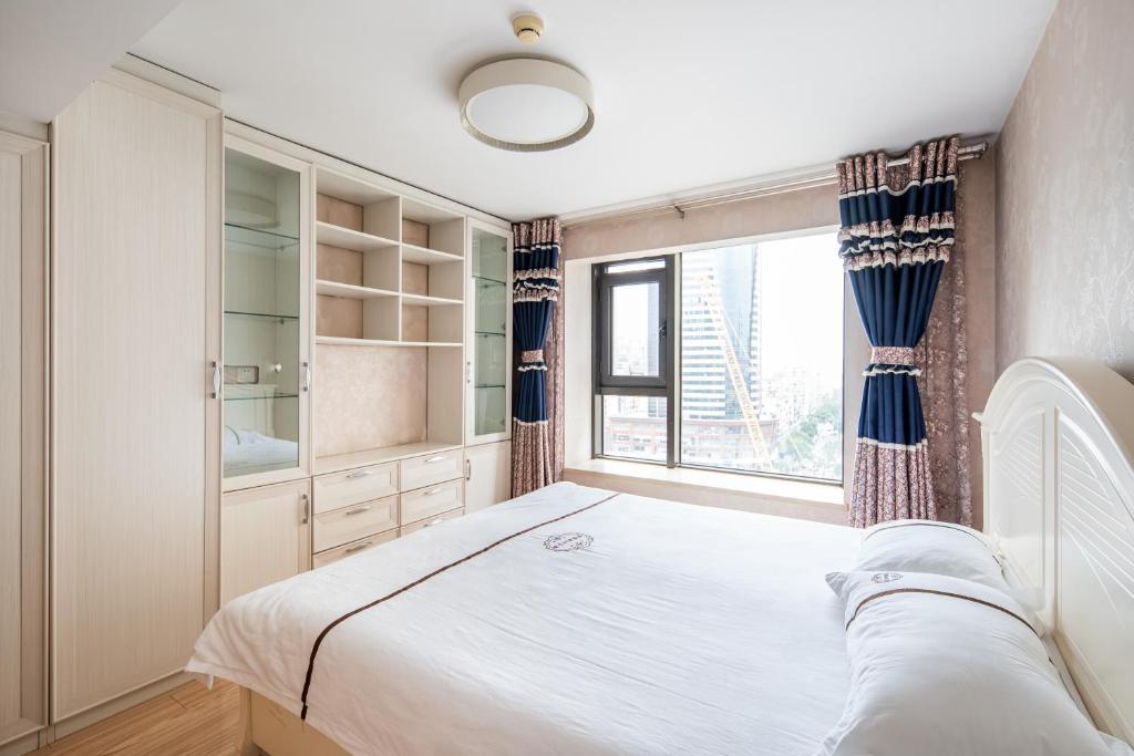 天津天津梦想家LOFT酒店式公寓的一间卧室设有一张大床和一个窗户。
