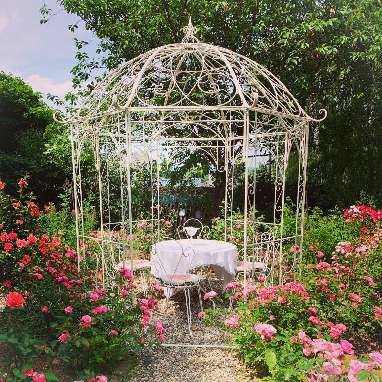 BeckerichIsabelle's Rosegarden的花园内带桌椅的白色凉亭