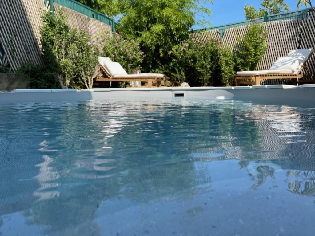 GriesAppartement T3 Aux Deux Cigognes Gries的庭院里的一个蓝色海水游泳池