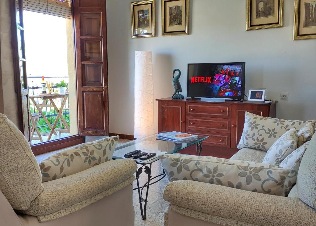 阿洛拉El Rancho Grande - Apartamento的客厅配有两把椅子和电视