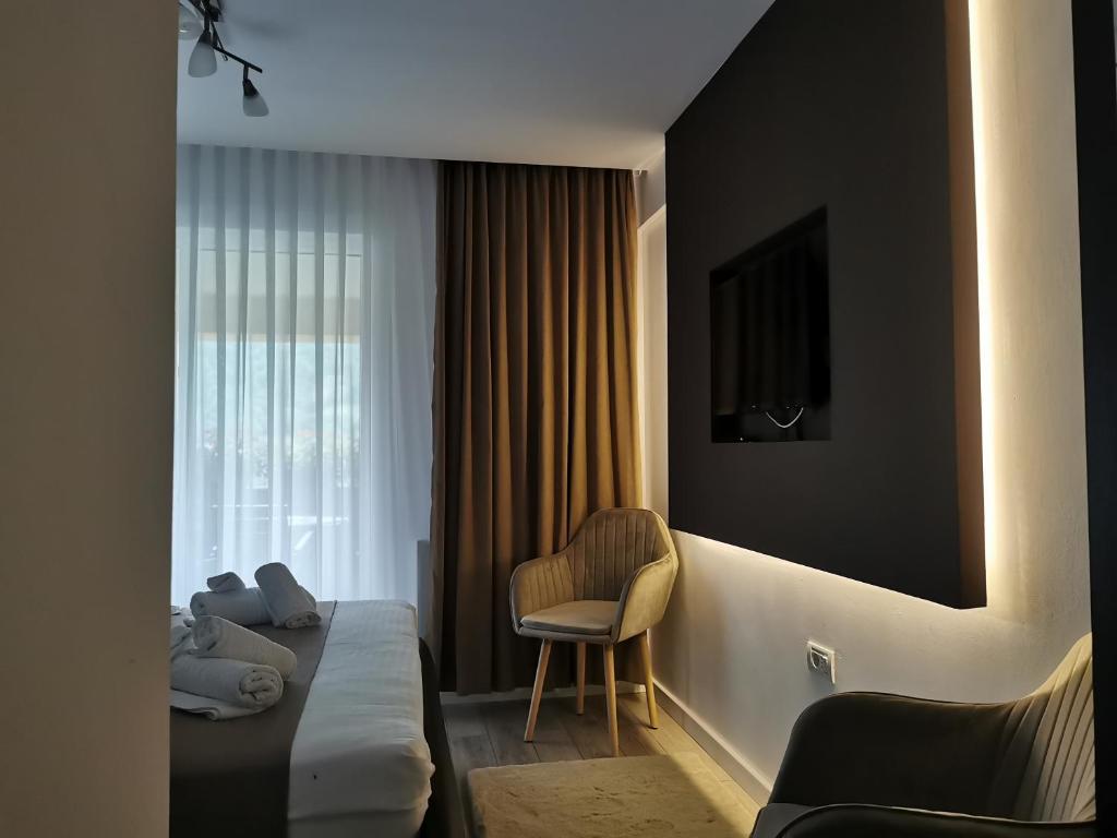 TeşilaDoftana Apartaments的配有一张床和一把椅子的酒店客房