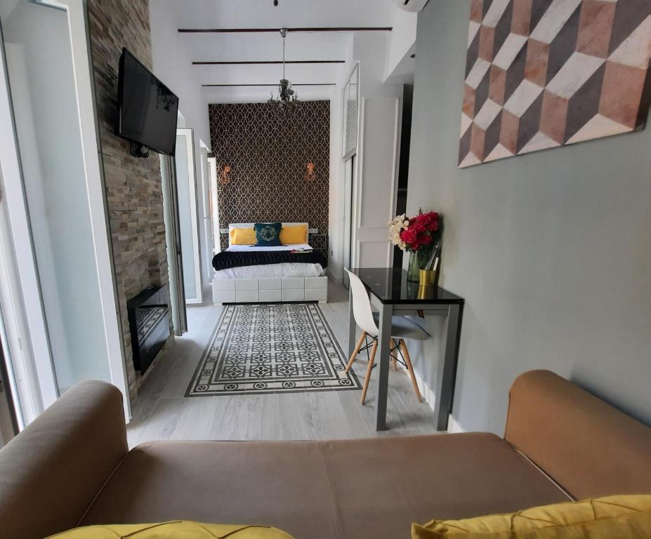 塞维利亚LA SUITE DEL CONDE LUXURY SUITES的客厅配有沙发和1张床