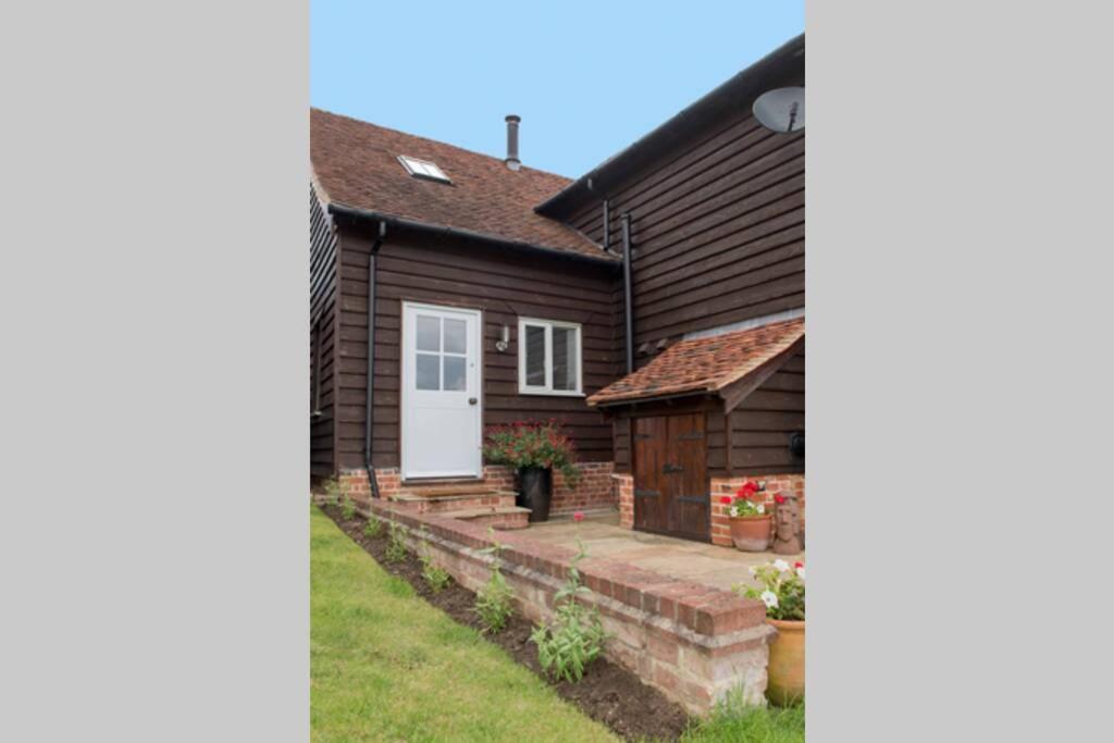 大邓莫Immaculate barn annexe close to Stansted Airport的白色门和院子的房子