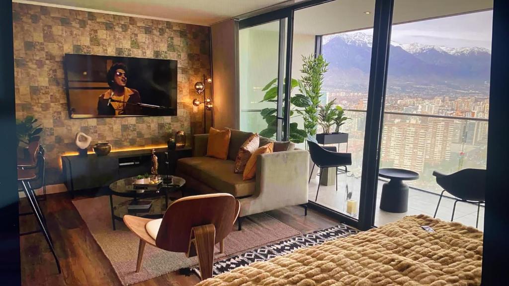 圣地亚哥Departamento de lujo en suite, en el piso 38, Las Condes, costado de parques y malls的客厅配有沙发和墙上的电视