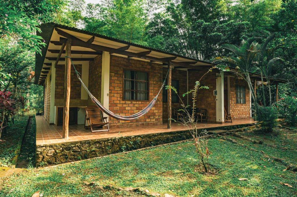 塔拉波托Huingos Eco Lodge的小屋前方设有吊床