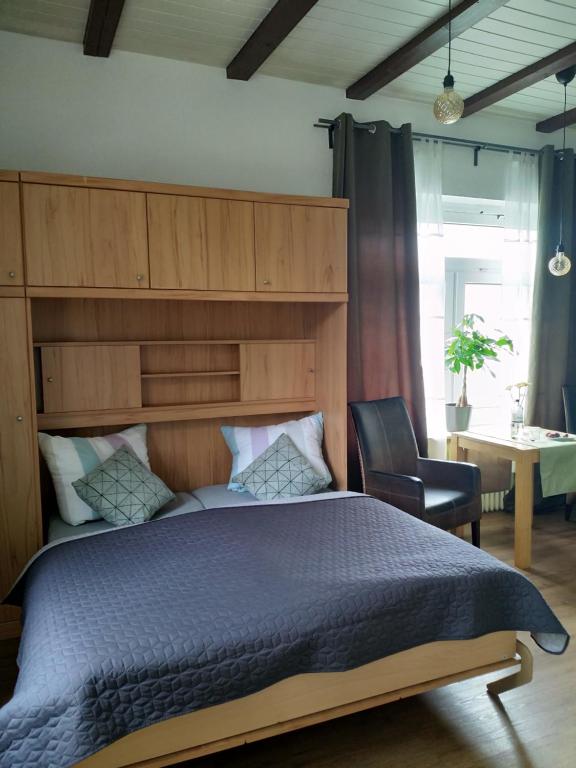 翁德洛Haus Heideblick的一间卧室配有一张大床和一把椅子
