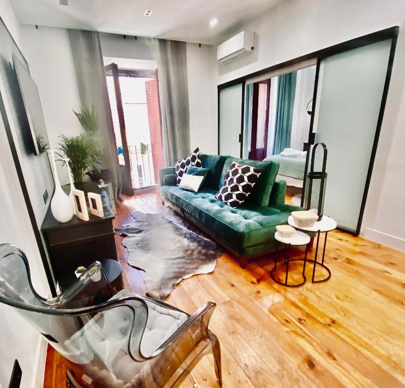 马德里Apartamento de diseño en Malasaña junto a Gran Vía的客厅配有绿色沙发和桌子