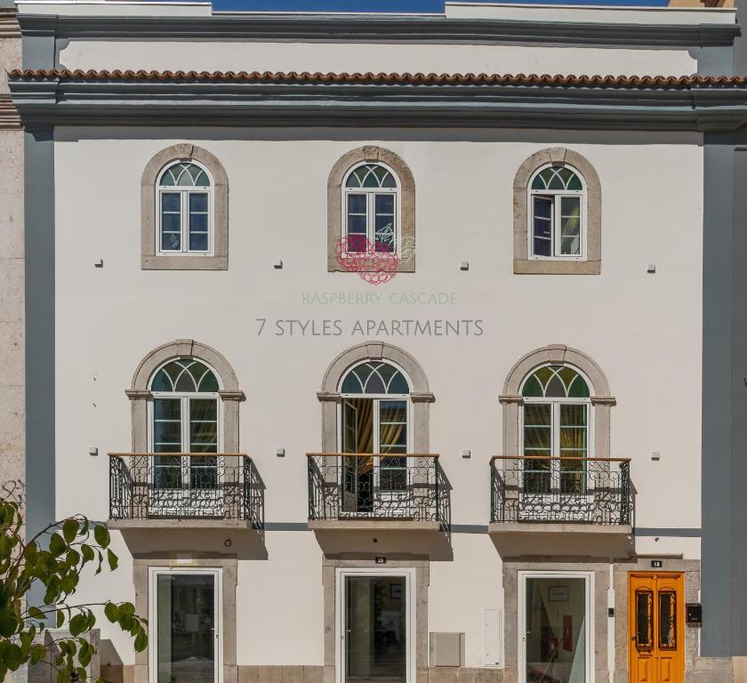 法鲁7 Styles Apartments by Raspberry Cascade的白色的建筑,设有窗户和阳台