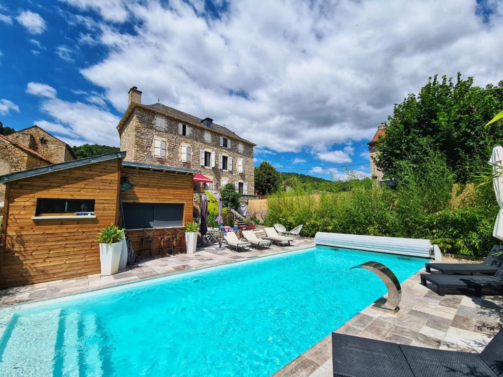 孔佩尔Le mas ROLLAND - Piscine & SPA - MILLAU-GORGES du TARN的房屋前的游泳池