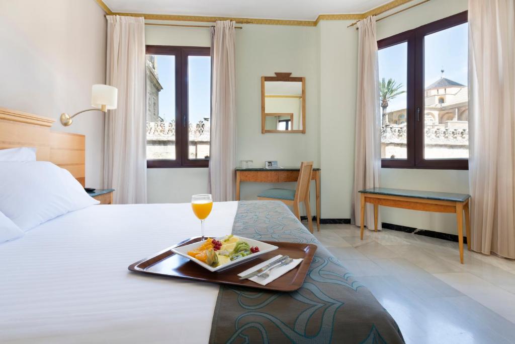 科尔多瓦欧洲之星迈蒙尼德酒店的一间酒店客房,床上放着一盘食物